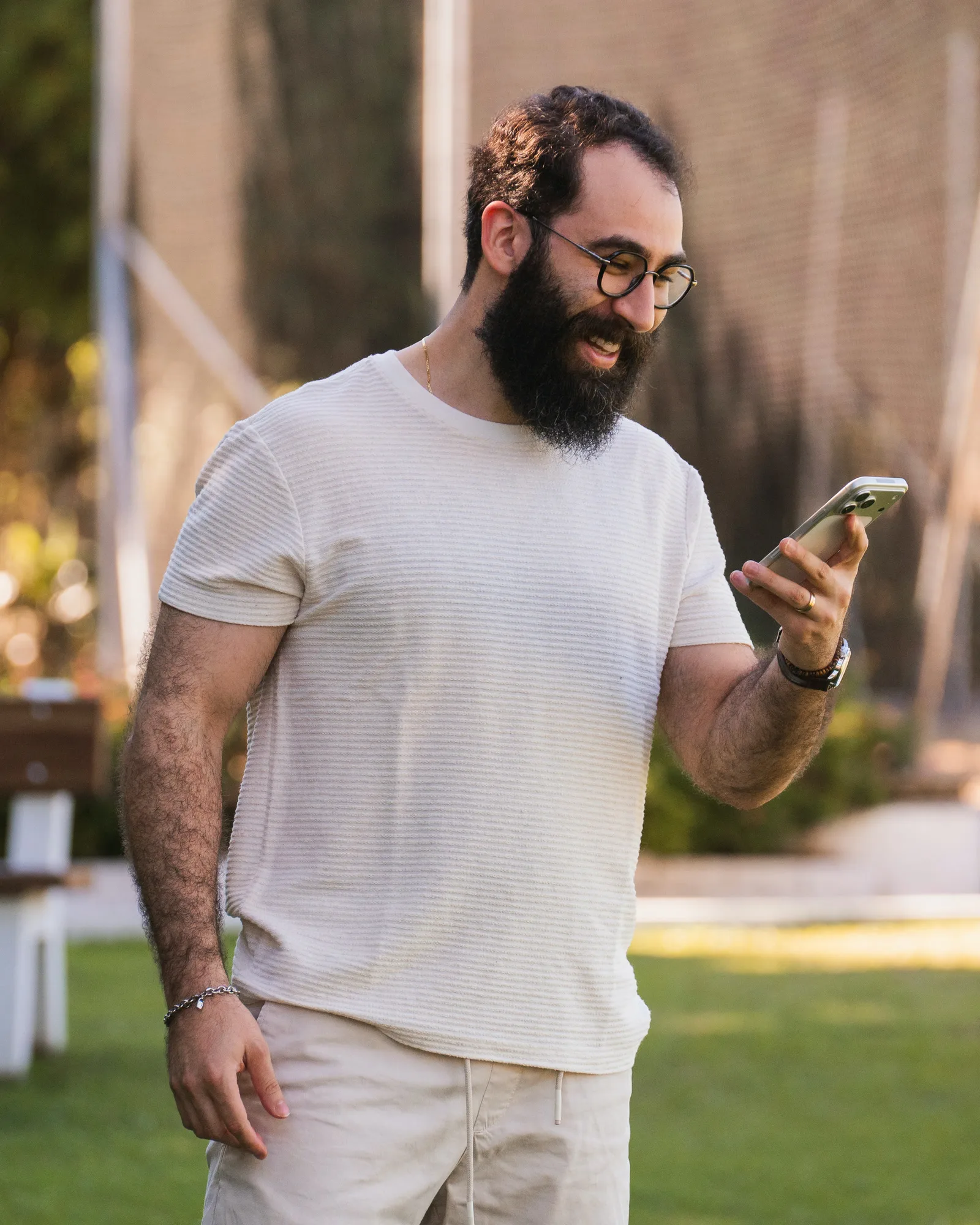 Elton Luiz sorrindo enquanto olha o celular